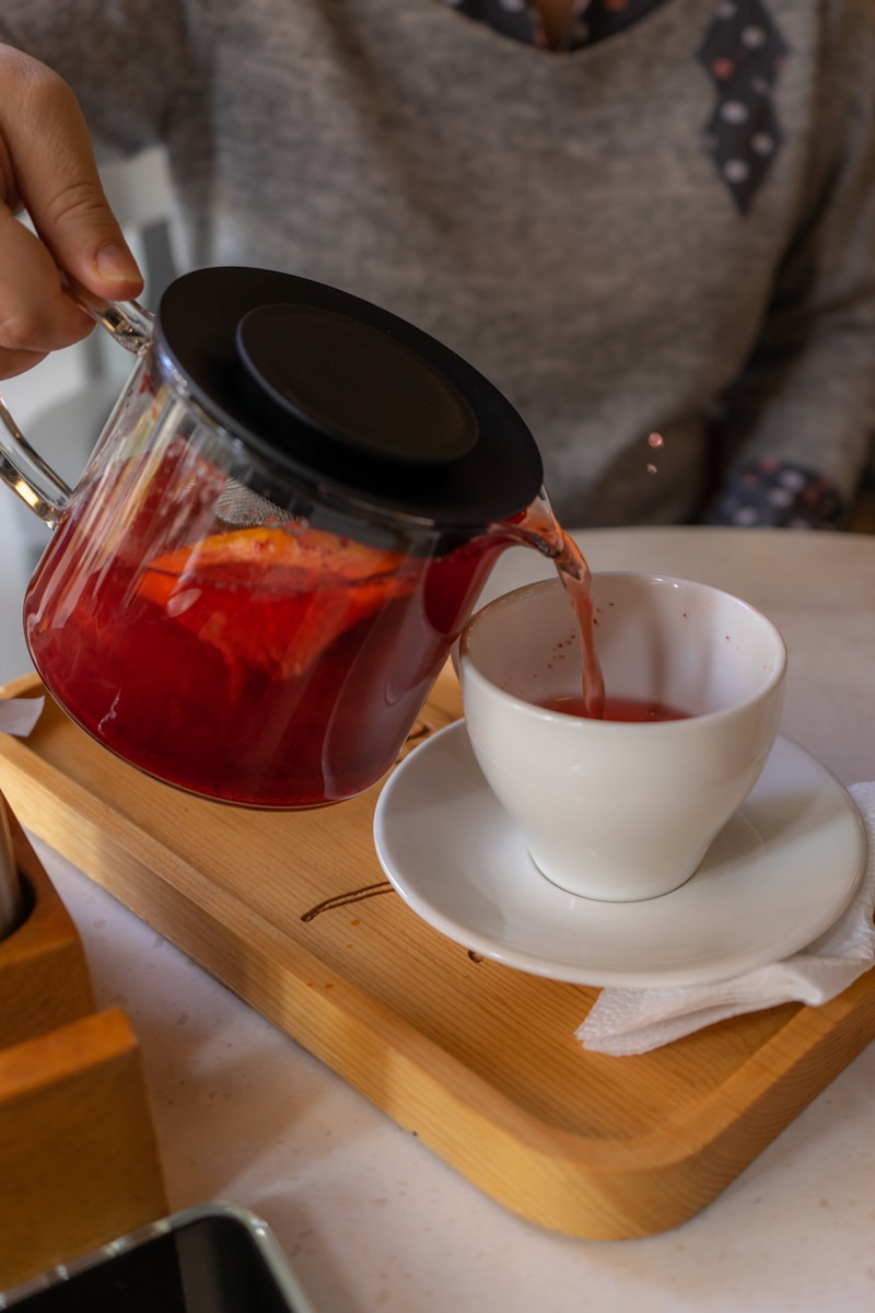 A person pours a cup of tea from a teapot