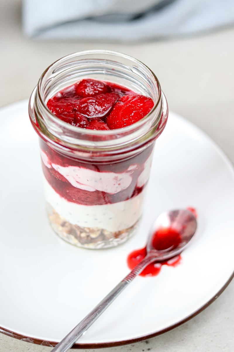 A jar of food on a plate with a spoon